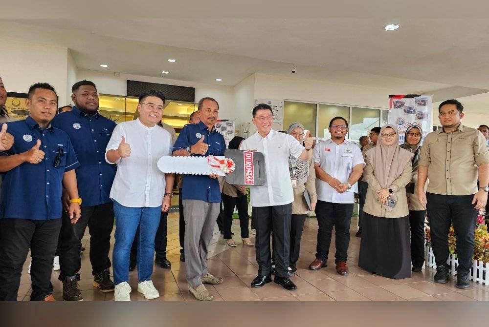 Kor Ming menyerahkan replika kunci jentera baharu MPTI kepada wakil pegawai di Teluk Intan pada Isnin.
