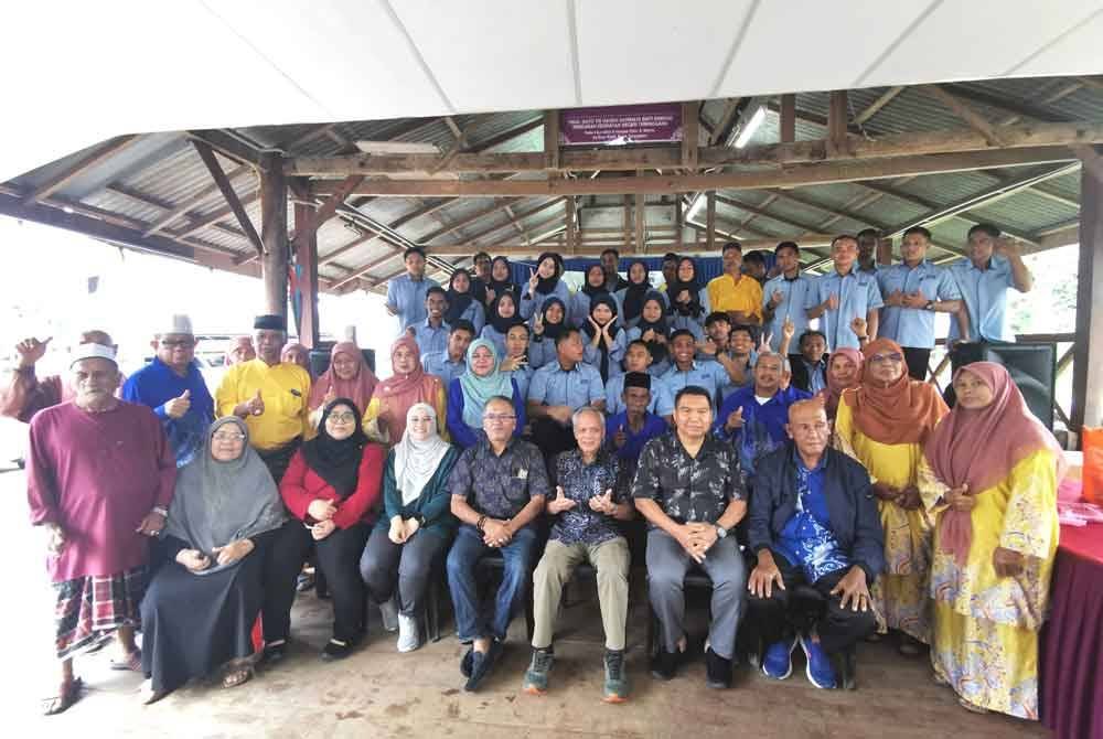 Muhammad Nasir (duduk, tengah) merakam gambar bersama preserta Program Keusahawanan Desa Universiti Pertahanan Malaysia (UPNM) ke Kampung Kayu Kelat pada Isnin.