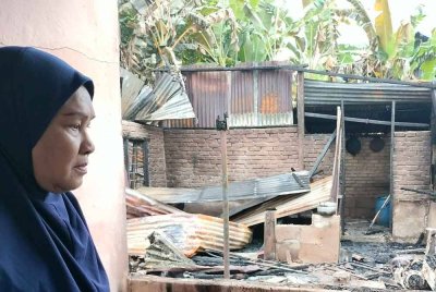 Nor Maidah melihat rumahnya yang hangus dalam kebakaran di Kampung Charuk Kapas, Kupang, Baling.
