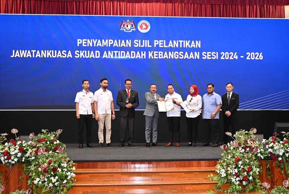 Ruslin (empat dari kiri) menyampaikan sijil penghargaan kepada ahli AADK semasa majlis Amanat Ketua Pengarah dan perhimpunan bulanan AADK 2025 di ibu pejabat AADK di Kajang, Selangor pada Selasa.
Foto: AADK.