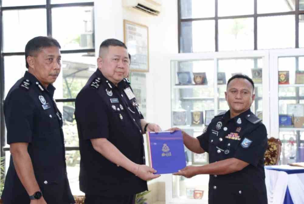 Kok Chin (dua dari kiri) menyampaikan sijil kepada pegawai polis ketika mengadakan lawatan kerja ke Briged PGA Kinarut, Papar.
