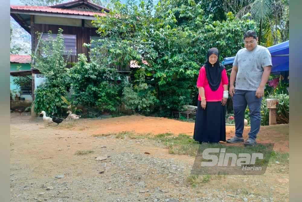 Salahudin dan ibunya menunjukkan lokasi yang didakwa terhidu bau petrol dekat rumah mereka di Kampung Bendang Padang, Kupang, Baling. Foto Sinar Harian