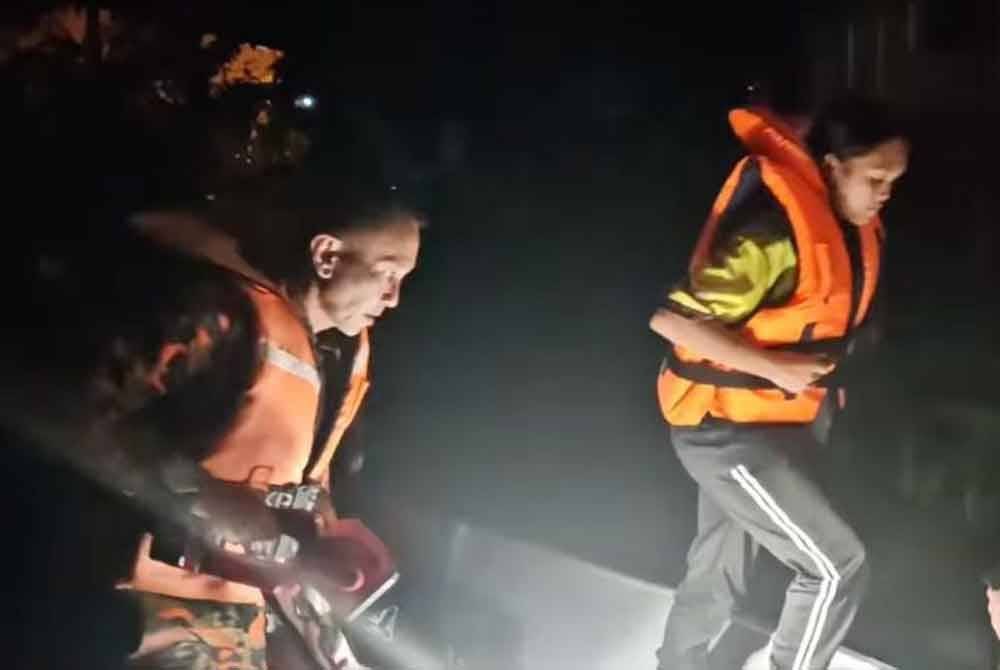 Anggota bomba membantu memindahkan calon peperiksaan SPM dari kediamannya di rumah panjang ke asrama sekolah.