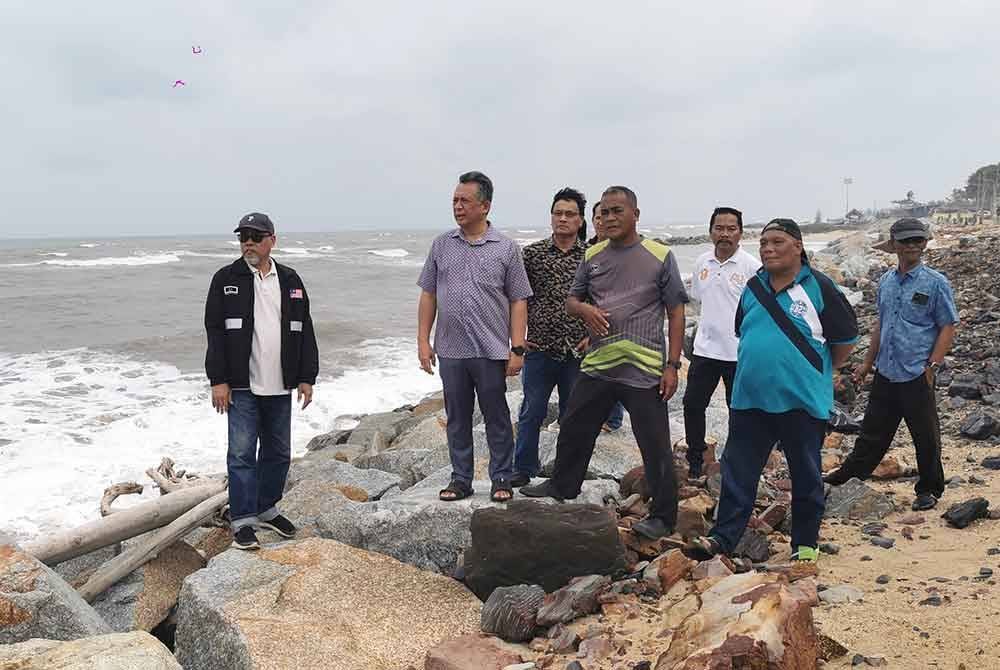 Ahmad Razif (dua, kiri) meninjau hakisan yang berlaku di pantai Mengabang Telipot, Kuala Nerus, petang Selasa.