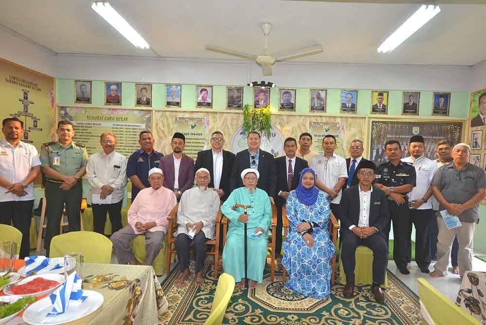 Mohd Khairuzzaman (duduk, kanan) merakam gambar bersama tetamu jemputan sempena majlis Perasmian SeBARU Gallery & Cafe di SK Kampung Baharu di Kuala Besut pada Selasa.