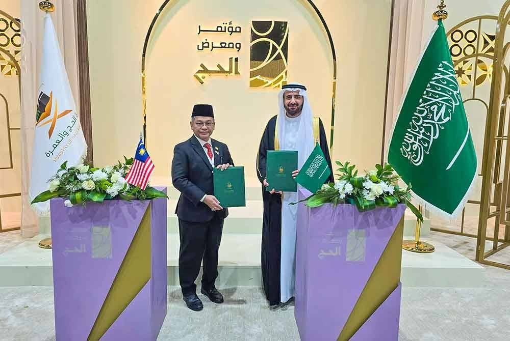 Mohd Na'im (kiri) bersama Tawfig selepas menandatangani Memorandum Urusan Haji.