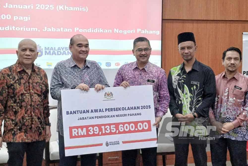 Ahmad Suhaimi (dua dari kiri) menyerahkan replika cek BAP kepada Amzan ketika majlis penyerahan cek cura BAP tahun 2025 peringkat Negeri Pahang di Auditorium Jabatan Pendidikan Negeri (JPN) Pahang di Indera Mahkota pada Khamis.