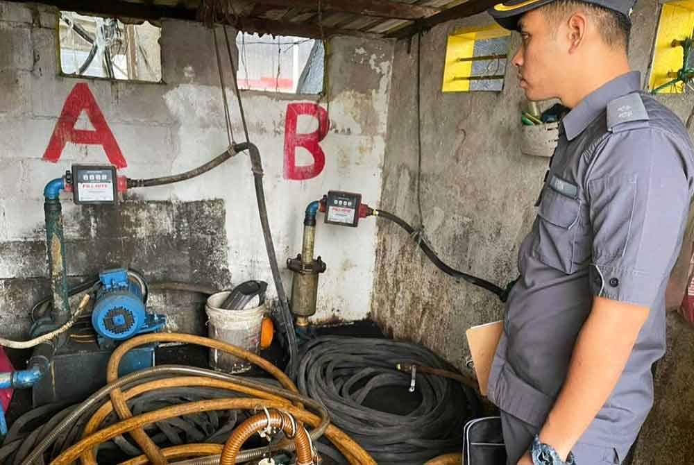 Anggota penguat kuasa KPDN Pahang melakukan pemeriksaan ke atas pam yang disyaki digunakan untuk memindahkan diesel diseleweng.