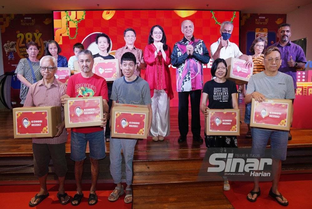 Michelle (enam dari kiri, belakang) Ameer (empat dari kanan, belakang) bergambar dengan penerima kongsi rezeki selepas melancarkan Kongsi Meriah sempena Sambutan Tahun Baharu Cina yang diadakan pada Khamis. Foto Sinar Harian/ROSLI TALIB