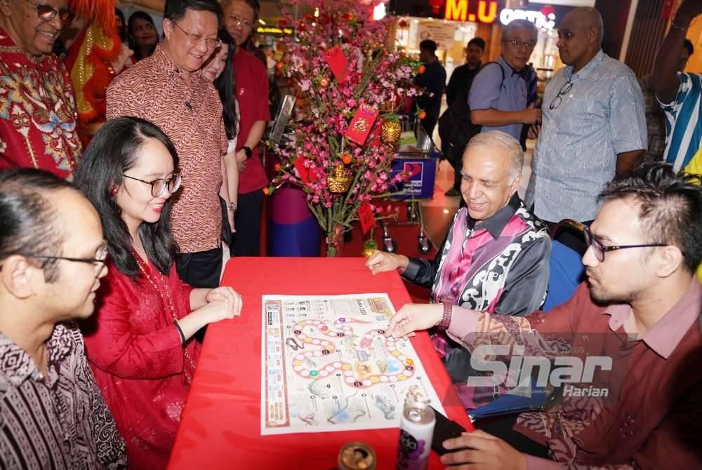 Michelle (dua dari kiri) dan Ameer (dua dari kanan) melihat permainan 'Snake Board Game' selepas melancarkan Kempen Kongsi Meriah 2025 sempena Sambutan Tahun Baharu Cina yang diadakan pada Khamis. Foto Sinar Harian/ROSLI TALIB