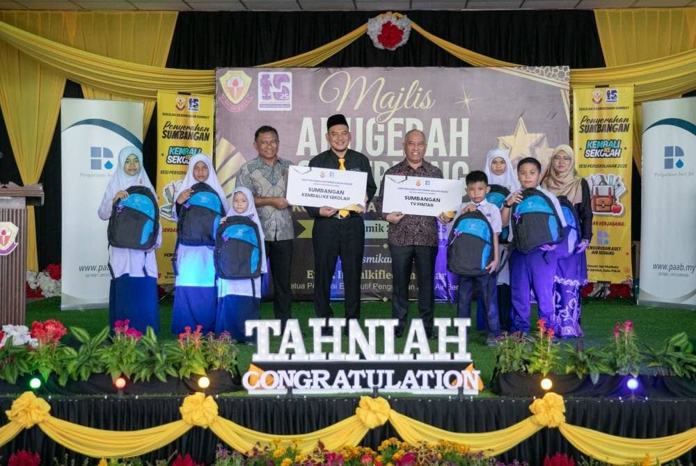 Dari empat kiri, Rozaifee, Herlman dan Zulkiflee bersama murid-murid SK Gambut menerima Kit Kembali ke Sekolah.