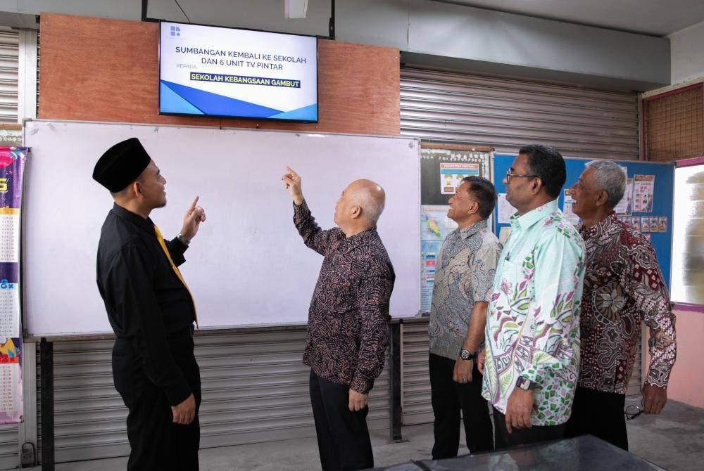 Dari kiri, Herlman, Zulkiflee, Rozaifee dan Harun melihat televisyen pintar yang telah siap dipasang bagi kegunaan murid di SK Gambut, Batu Pahat, Johor.