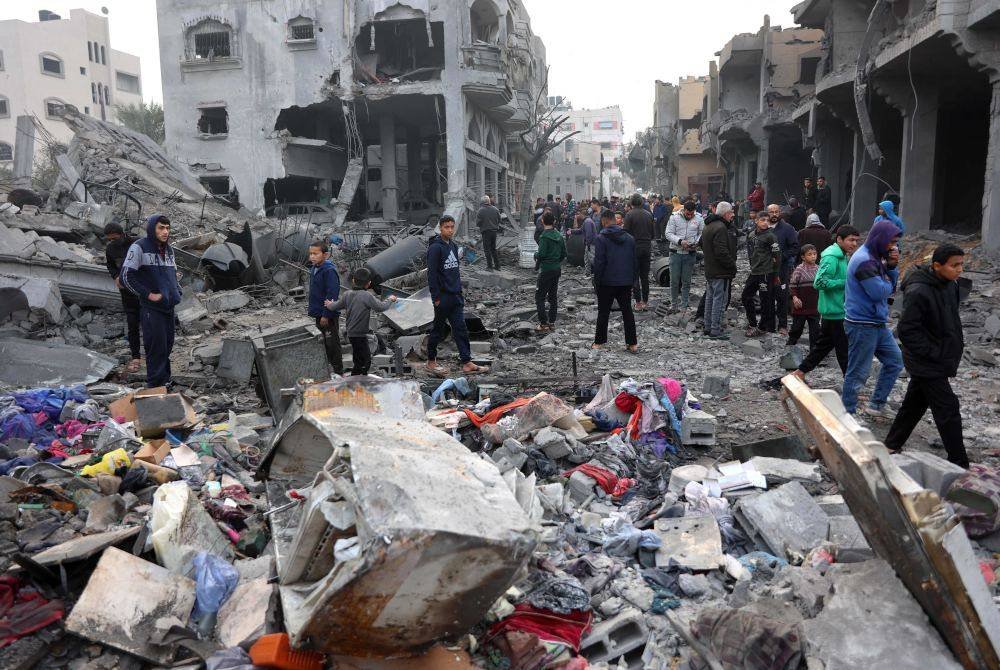 Rakyat Palestin memeriksa runtuhan bangunan yang dilanda serangan Israel di Jabalia, utara Semenanjung Gaza selepas pengumuman gencatan senjata. Foto AFP