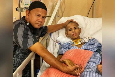 Adnan bersama anaknya, Muhamad Bahaman yang terlantar sejak kemalangan jalan raya pada September lalu. Foto ihsan Adnan.