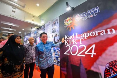 Kor Ming (kanan) melihat replika Kad Laporan KPKT 2024 yang diletakkan di ruang legar dewan kementerian semasa hadir pada Majlis Amanat Tahun Baharu 2025 pada Khamis. Turut sama timbalannya, Datuk Aiman Athirah Sabu (kiri) dan Ketua Setiausaha KPKT, Datuk M Noor Azman Taib. Foto Bernama