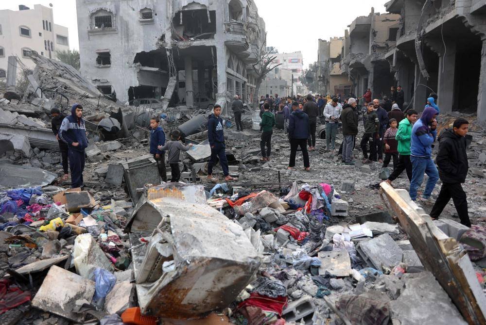 Rakyat Palestin memeriksa runtuhan bangunan akibat serangan Israel di Jabalia, utara Semenanjung Gaza susulan pengumuman gencatan senjata.