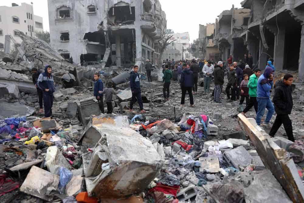 Rakyat Palestin memeriksa runtuhan bangunan akibat serangan Israel di Jabalia, utara Semenanjung Gaza susulan pengumuman gencatan senjata. - Foto: Agensi