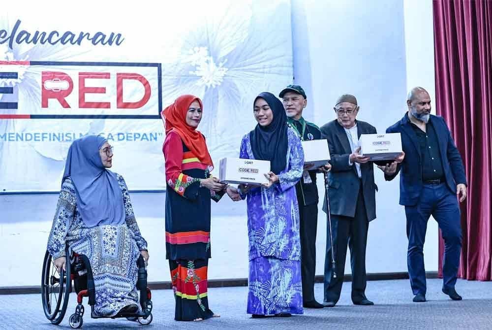 Noraini (dua dari kiri) menyampaikan ‘hygine pack’ kepada remaja perempuan selepas melancarkan Kempen CODE RED di Masjid Wilayah, Kuala Lumpur pada Khamis malam.