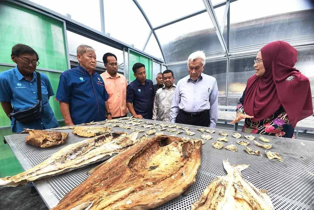 Abdul Aziz (dua dari kanan) melihat produk ikan kering yang dikeringkan di dalam kubah pengering solar. Turut kelihatan Mohd Faudzi (empat dari kiri)