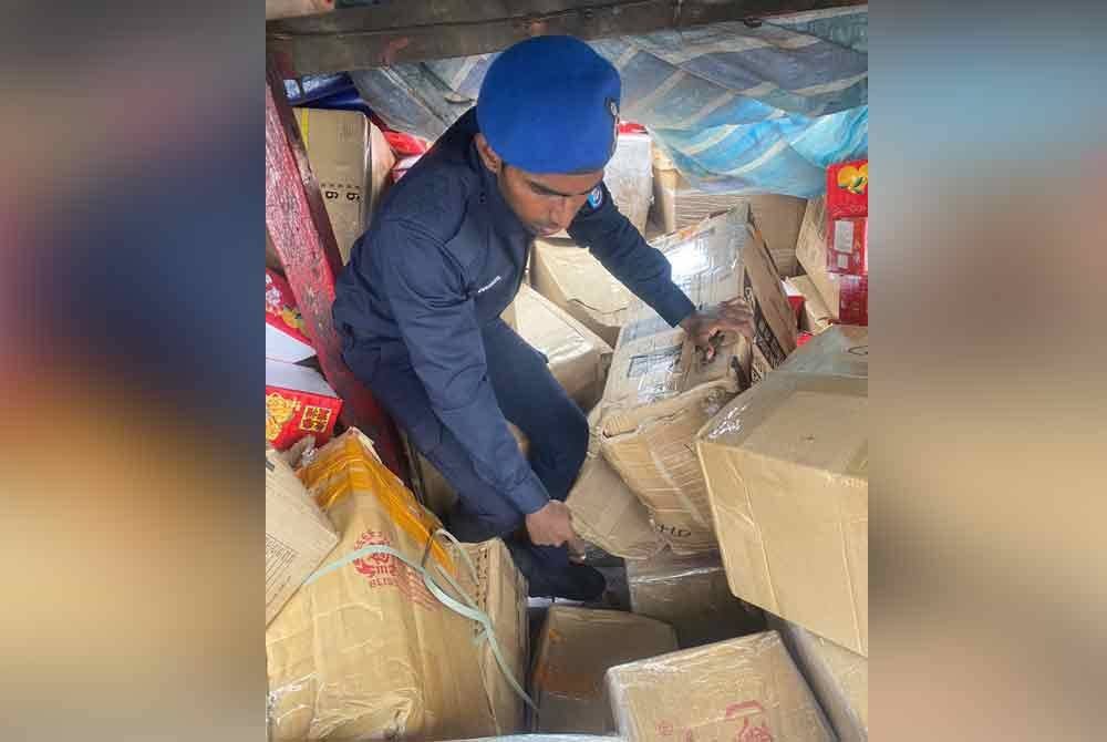 Anggota PPM menunjukkan timbunan kotak yang mengandungi barang kawalan dipercayai cuba diseludup keluar.