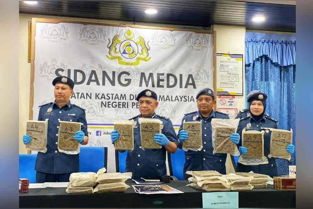 Ismail (dua dari kiri) menunjukkan ganja yang berjaya dirampas di Bukit Putih pada 6 Januari lalu.