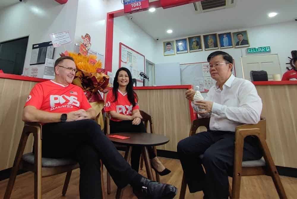 Kon Yeow menikmati aiskrim di Pos Shop Datuk Keramat sambil diperhatikan oleh Charles Brewer.