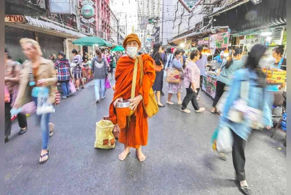Seorang sami Buddha memakai topi musim sejuk di Bangkok. Foto Agensi