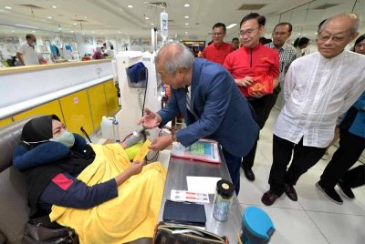 Tian Hock memberi angpau kepada pesakit yang menjalani rawatan dialisis di Pusat Perubatan Mawar.