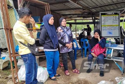 Susanti (kanan) bersama ahli keluarganya yang menunggu di Pusat Kawalan Operasi (PKO) di Jeti Nelayan Padang Temu di sini, pada Jumaat.