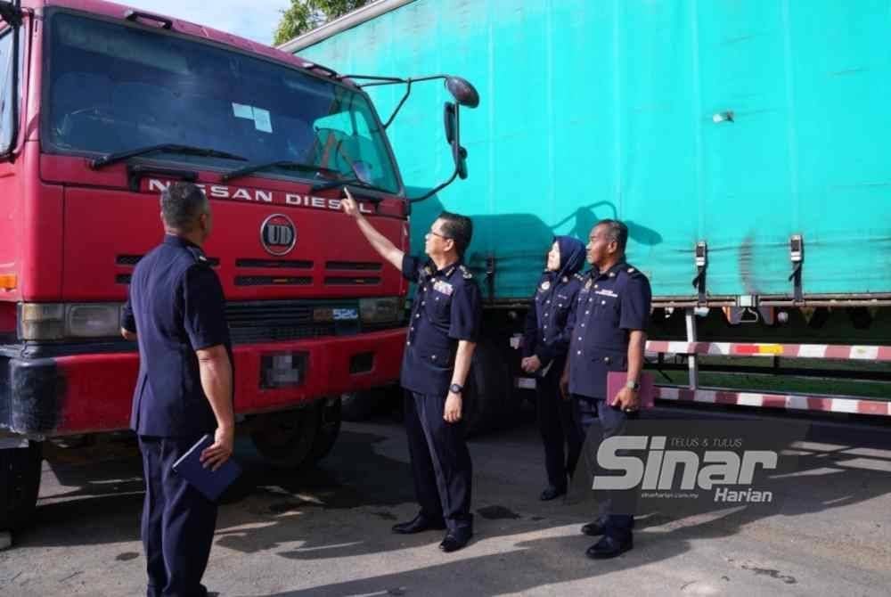 Azrin bersama pegawainya meninjau lori yang disita menerusi Op Gempur Teknikal baru-baru ini. Foto Sinar Harian - MOHD HALIM ABDUL WAHID