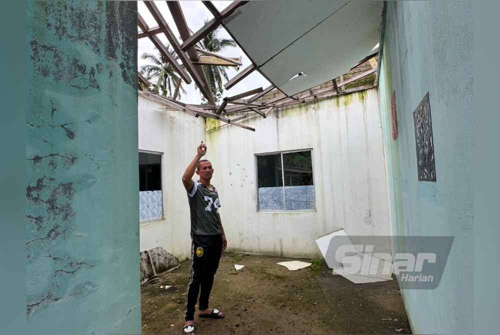 Wan Rozee menunjukkan bumbung rumah yang rosak. FOTO SINAR HARIAN-ADILA SHARINNI WAHID.