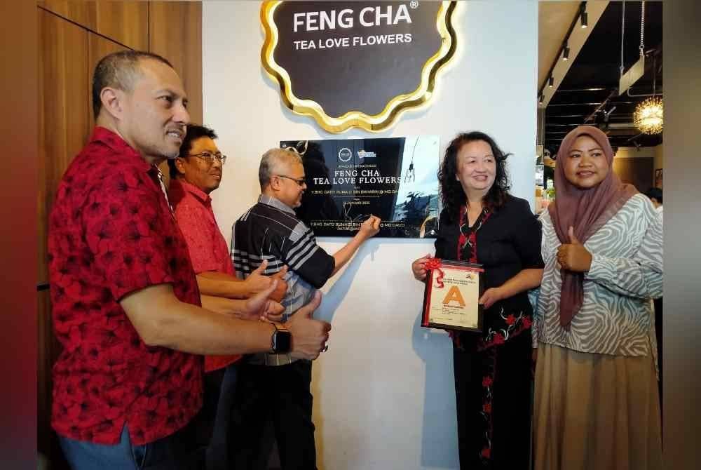 Rumaizi (tengah) menyempurnakan gimik pelancaran sempena Majlis Pembukaan Restoran Feng Cha TLF, di Pusat Perdagangan Canning II di Ipoh pada Sabtu.