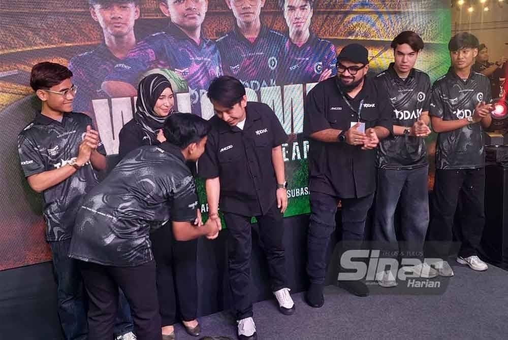 Adam Adli (empat dari kiri) bersalam dengan penggiat sukan e-sukan semasa melancarkan sebuah butik menjual pakaian berjenama tempatan di Shah Alam, pada Sabtu. Foto Sinar Harian, Mohd Faizul Haika Mat Khazi