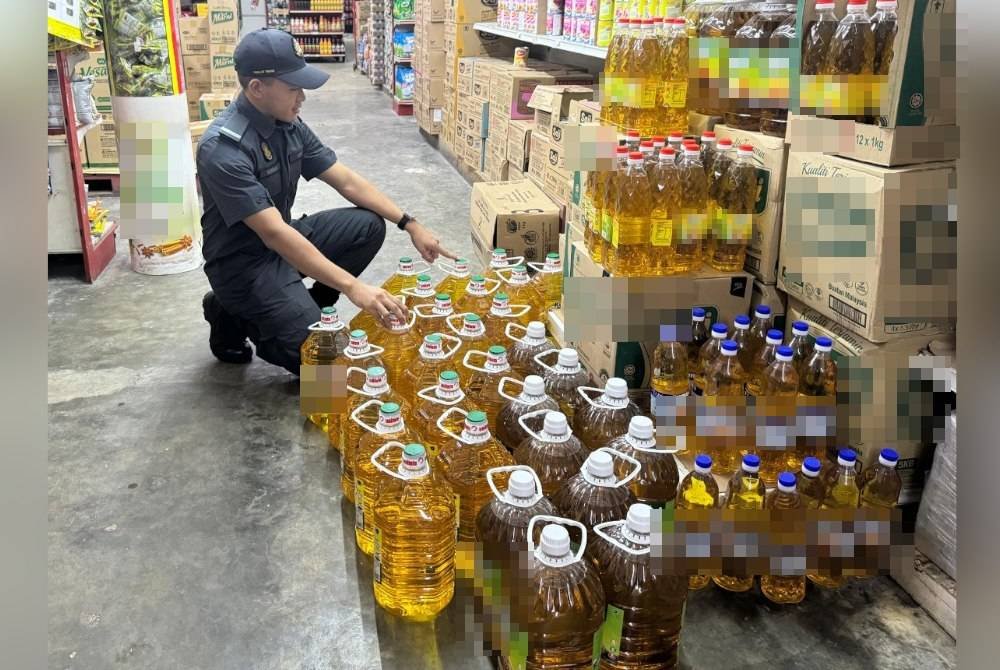 Anggota penguat kuasa KPDN Cawangan Teluk Intan melakukan pemeriksaan terhadap bekalan minyak masak jenis botol di sebuah pasar mini di Teluk Intan. Foto KPDN Perak