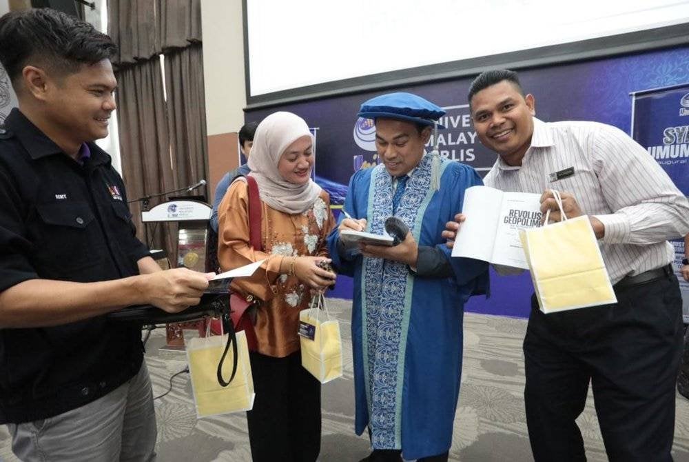 Profesor Dr Mohd Mustafa menandatangani bukunya selepas menyampaikan syarahan umum profesor bertajuk Revolusi Geopolimer: Asas dan Potensi Aplikasi Termaju dalam Teknologi Mampan di UniMAP pada Selasa lalu. Foto UNIMAP
