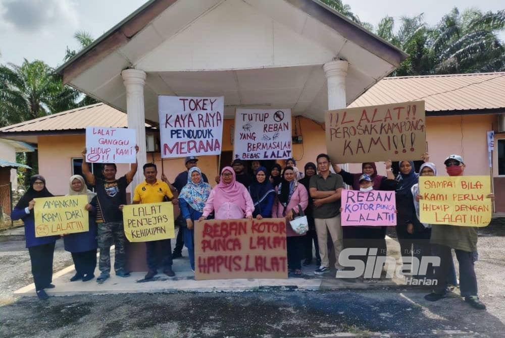 Saluah (enam dari kiri) bersama penduduk Kampung Ladang Batu membuat bantahan di balairaya kampung berkenaan pada Ahad.