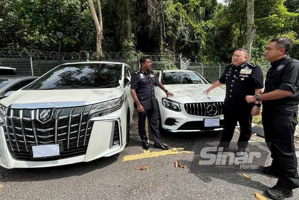 Kok Chin (dua dari kanan) melihat kenderaan mewah yang disita.