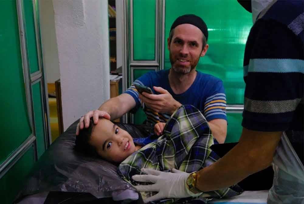 Danial Benoit menemani anaknya, Lucas ketika proses berkhatan sempena Program Khatan Perdana 2025 DUN Ru Rendang di Marang pada Sabtu. Foto Jihadi Urusetia Penerangan Darul Iman (UPDI)