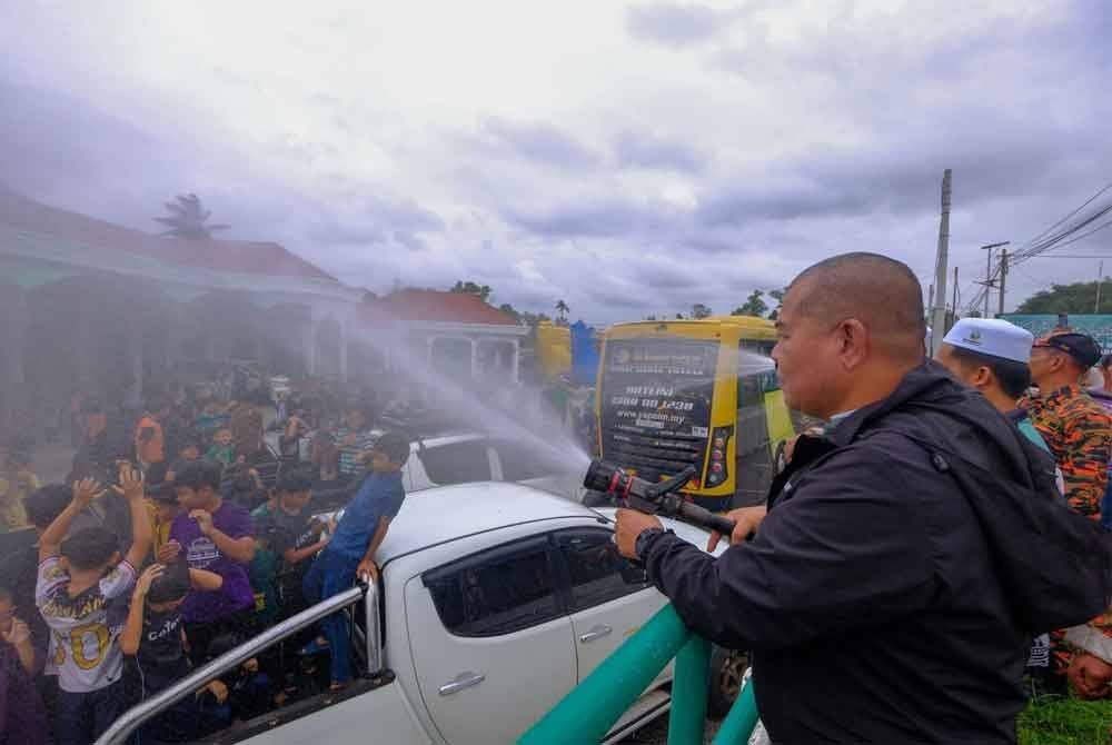 Peserta program khatan beramai-ramai disiram air dari pili bomba sempena Program Khatan Perdana 2025 DUN Ru Rendang di Marang pada Sabtu. Foto Jihadi Urusetia Penerangan Darul Iman (UPDI).