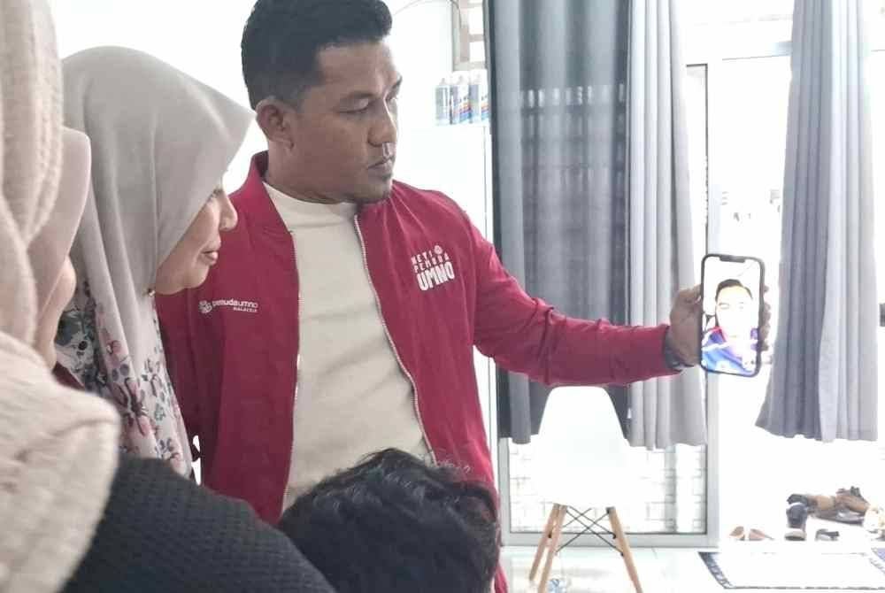 Faridah (dua dari kanan) berbual melalui panggilan video bersama Akmal.