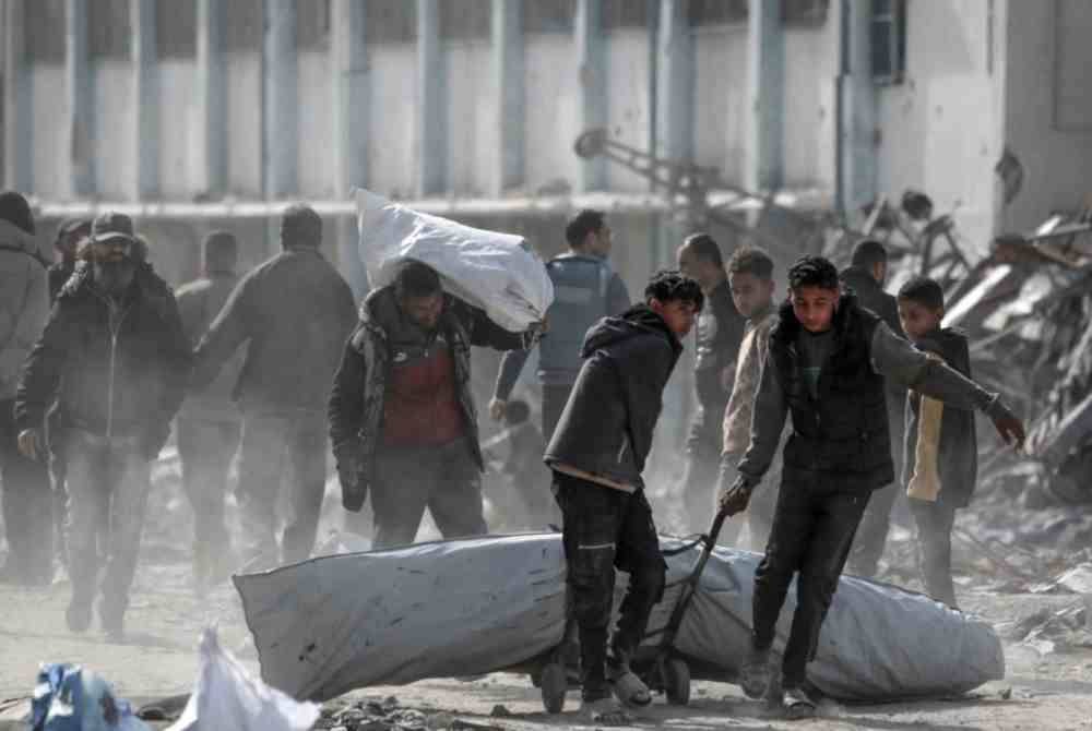 Penduduk Palestin yang dipindahkan membawa barang-barang mereka ketika mereka kembali ke Rafah tengah di selatan Semenanjung Gaza selepas gencatan senjata antara Israel dan gerakan Hamas berkuat kuasa. - Foto: AFP