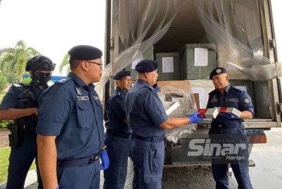 Wan Jamal Abdul Salam (kanan) memeriksa lori yang membawa rokok seludup semasa sidang media di Pejabat Bahagian Penguatkuasaan JKDM Cawangan Pengkalan Kubur pada Ahad.