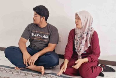 Faridah (kanan) bersama anak lelakinya ketika ditemui di rumahnya di Kampung Mak Chili, Kemaman pada Ahad.