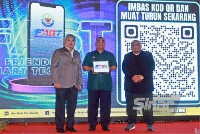 Muhammad Sanusi (tengah) menunjukkan aplikasi FAST selepas pelancaran di Alor Setar.