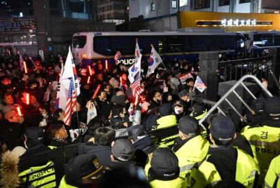 Pasukan keselamatan menghalang penyokong Suk Yeol yang cuba menceroboh Mahkamah Daerah Barat Seoul pada Ahad. Foto AFP