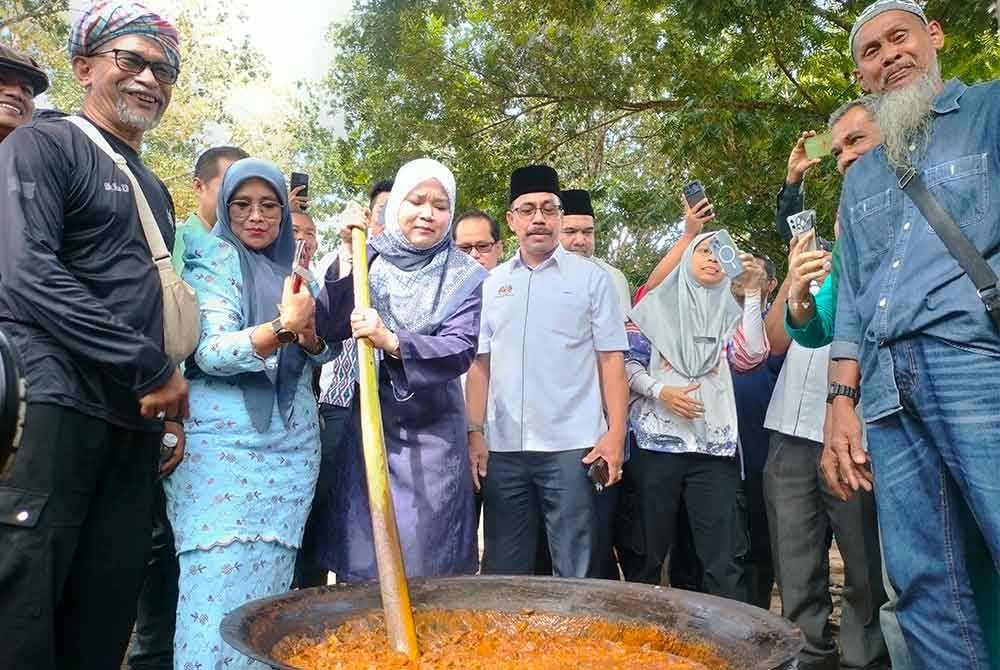 Fadhlina mengacau gulai kawah yang dimasak secara gotong-royong sempena Kenduri Rakyat di Sekolah Kebangsaan Danglau Sik Kedah pada Isnin.