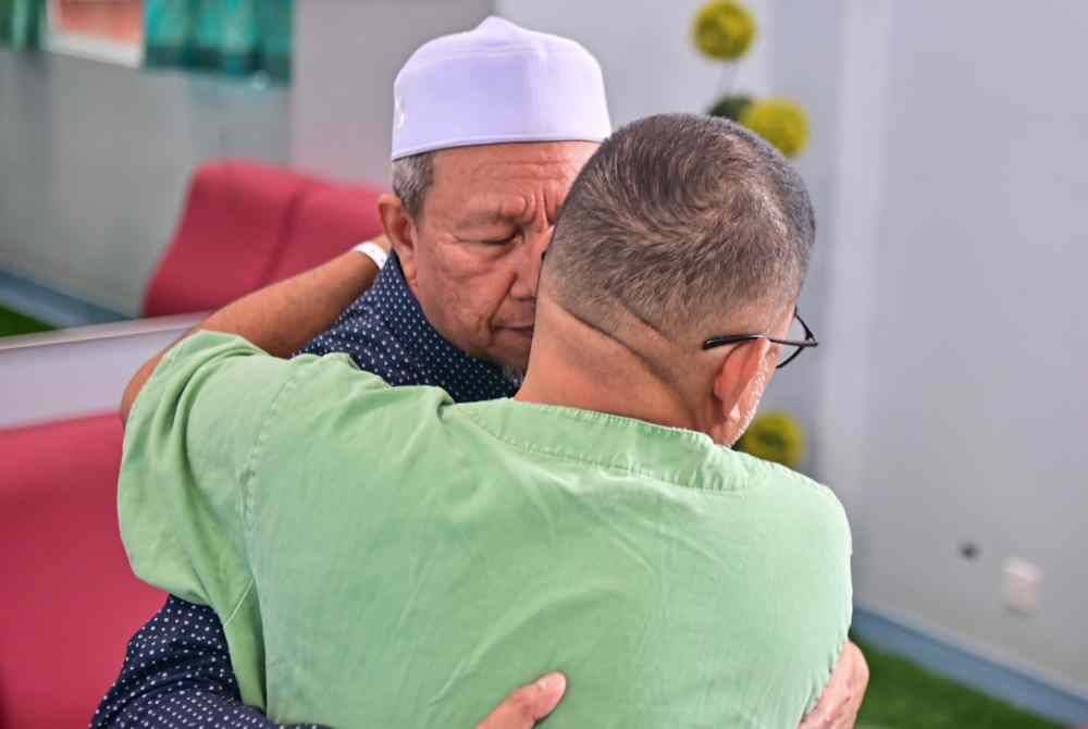 Maliaman memeluk Ahmad Nor Al Faizan ketika ditemui di klinik pakar psikiatri HSNZ di Kuala Terengganu.