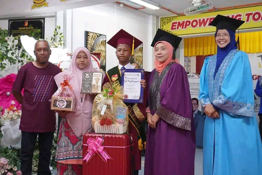 Norhaidah (dua dari kiri) dan Hirwan (kiri) meraikan kejayaan Hazim (tengah) yang terpilih menerima anugerah cemerlang kokurikulum SK Seri Makmur pada Khamis.