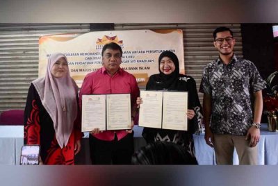 Nik Rosmawati (dua, kanan) bersama Nazri (dua, kiri) menunjukkan dokumen MoU yang ditandatangani bagi membantu peniaga.