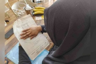 Mashitah menunjukkan list tanah milik arwah bapa yang kini telah dinaikkan rumah pihak lain.